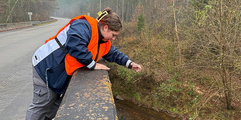Anna Privette - Water and Soil Quality Division, pulling a sample from Thompson Creek